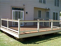 <b>Trex Composite deck with white facia wrap and white vinyl railing with matching cap board and black ballusters</b>